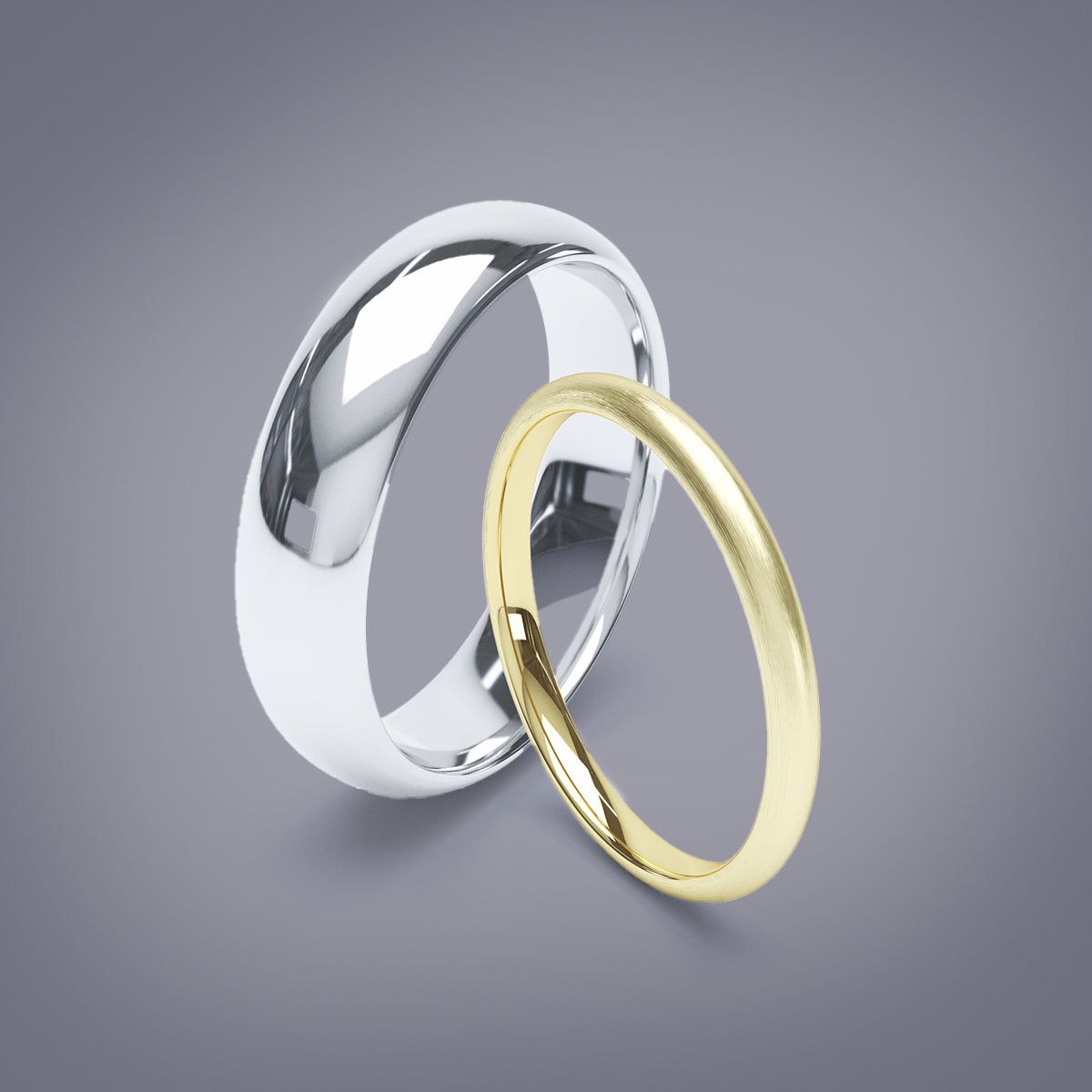 A platinum and a brushed yellow gold wedding band leaning against each other